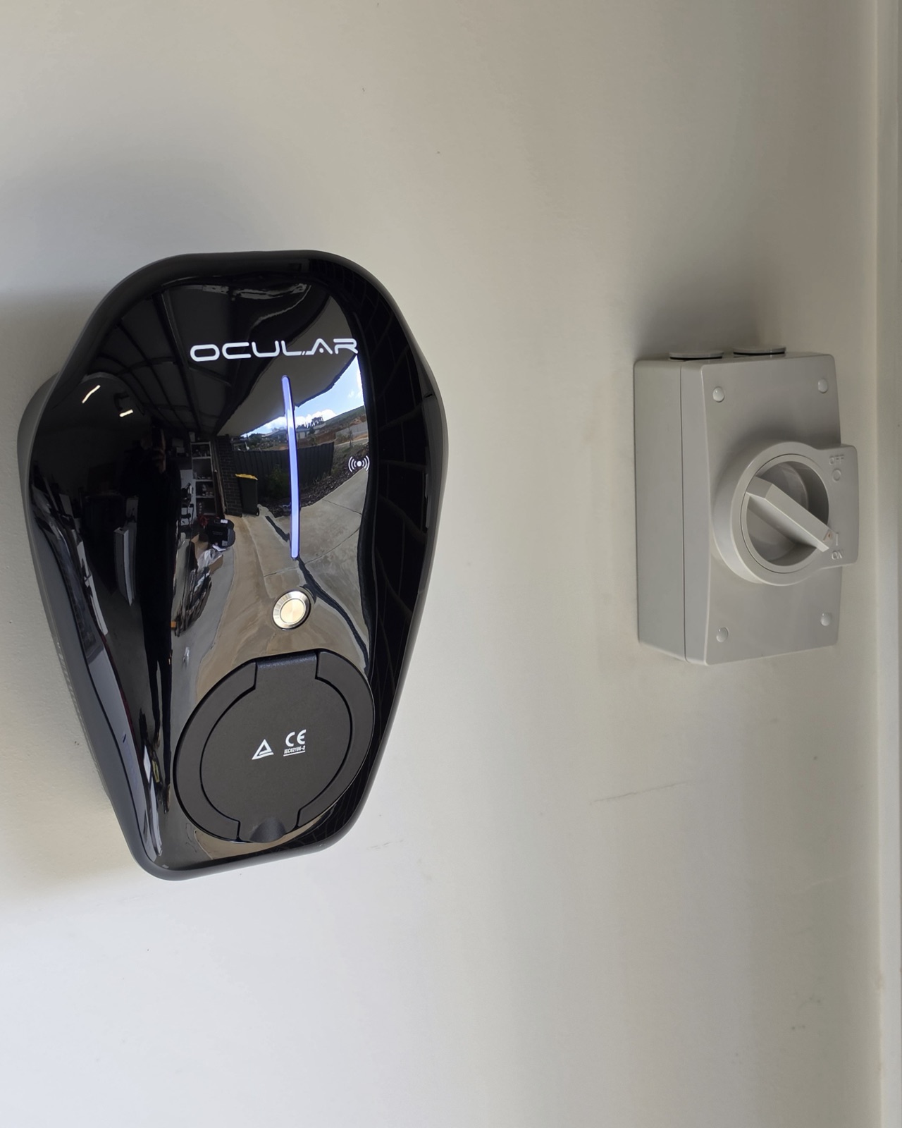 Ocular EV charger installed on a residential wall beside an isolator switch